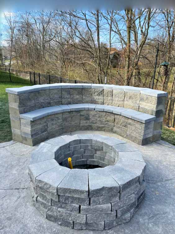 a beautiful fire pit with bench wall