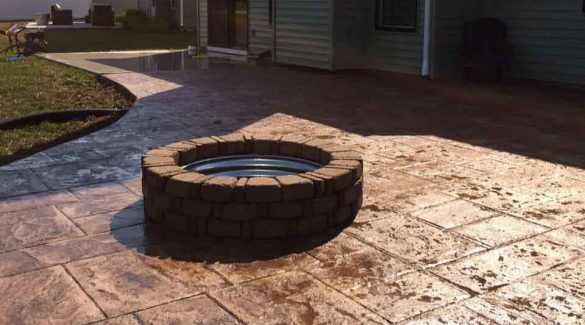 colored concrete stamped patio with brick firepit